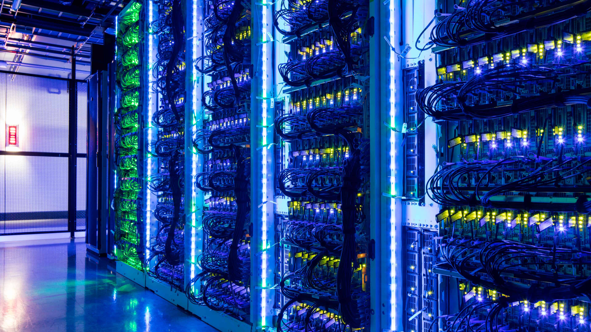 Rows of illuminated server racks and cabling inside a data center